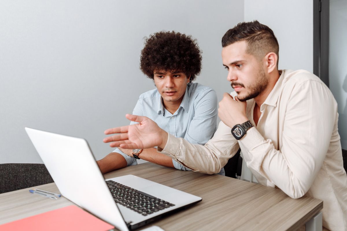 دو همکار در حال بررسی یک پروژه روی لپ‌تاپ